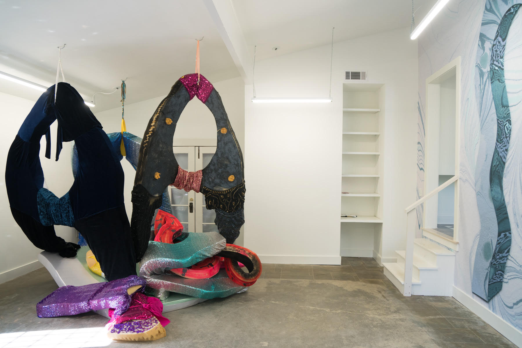 Installation view of "Porthole Portico" exhibition at Camayuhs gallery, with sculpture by Jaime Bulll and wallpaper by Lauren Clay. 