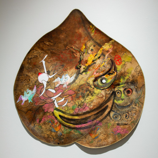 a large mask in the shape of an upside down peach with multicolored designs