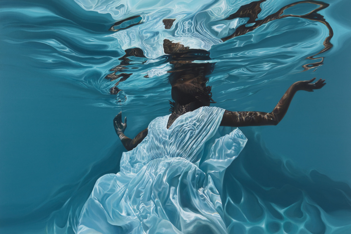 a darker-skinned Black woman floating beneath cerulean waters, the figure wears a white dress and is positioned with head back and arms out stretched, their dress catching the light of every wave