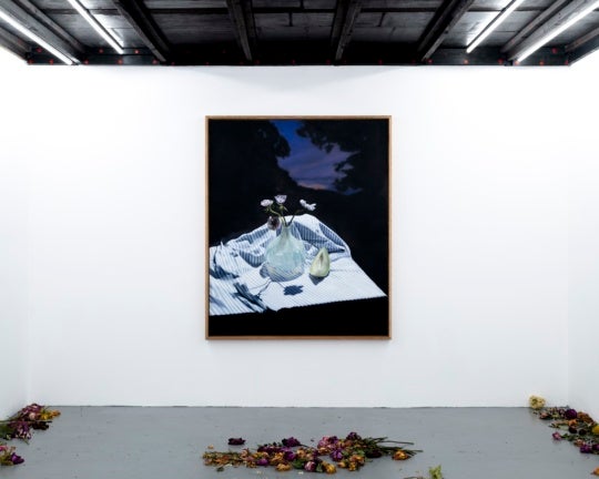 installation view of painting with flowers on the ground